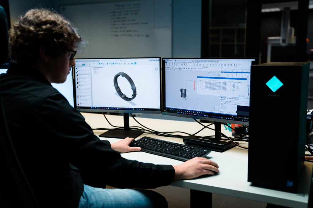Engineer using CAD software to optimize 3D design for printing, showing detailed product visualization and technical specifications